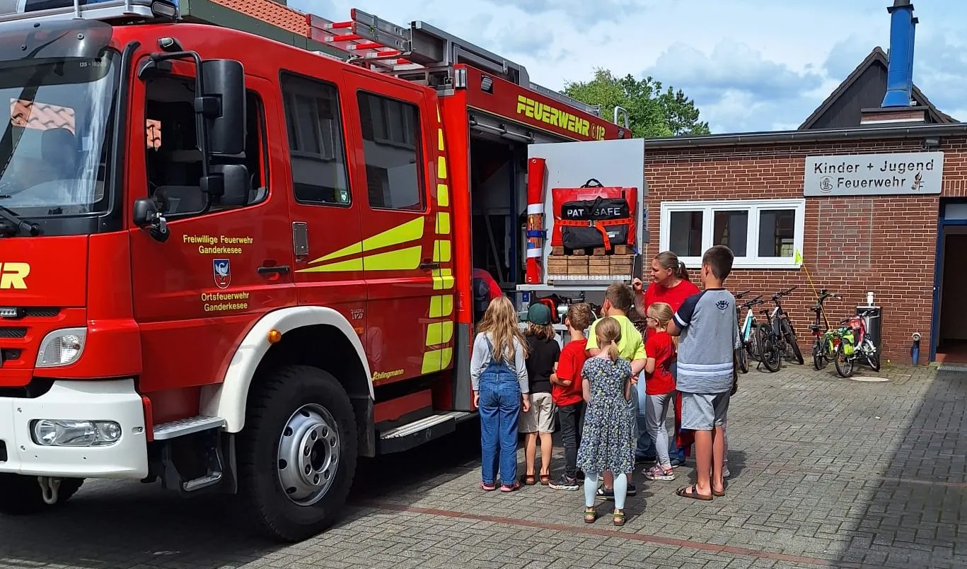 Kinderfeuerwehr am Feuerwehrauto